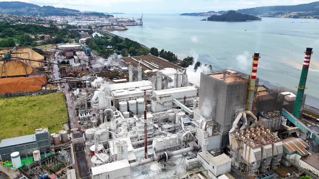 Aerial view of industrial pulp mill factory emitting smoke