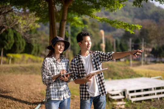 Agricultural team surveying land using digital tablet