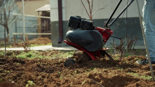Motor cultivator standing on freshly tilled garden soil
