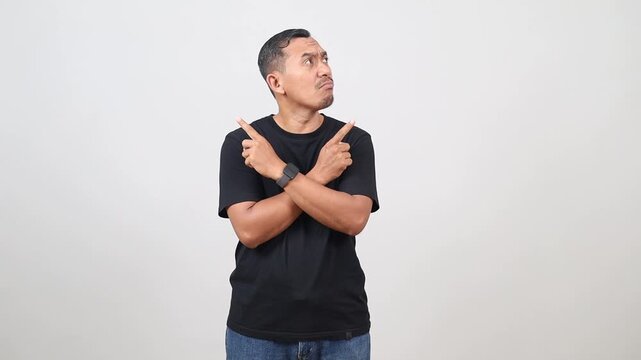 Confused Asian man pointing both sides with doubtful face expression