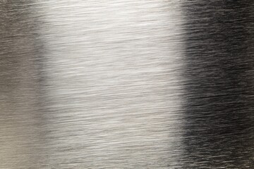 Fototapeta premium Brushed silver metal texture with bright horizontal light gradient, ideal for industrial backgrounds and modern design layouts