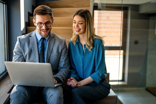 Business team of two executives working together using laptop in office. Technology concept