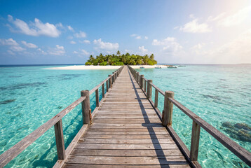 Fototapeta premium Long wooden pier over clear water leading to a lush tropical island