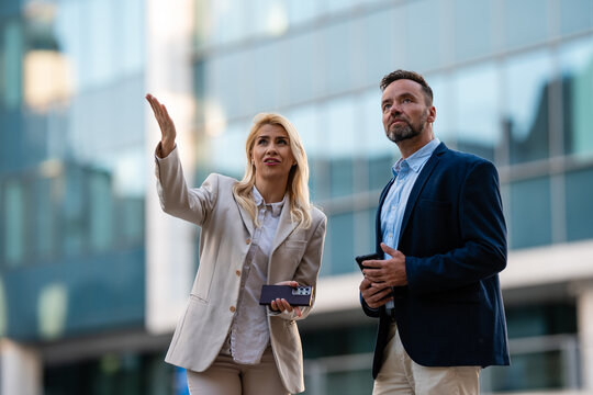 Business professionals discussing urban development and real estate outdoors
