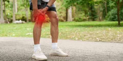 Fototapeta premium Asian man with knee pain during outdoor sport activity in park