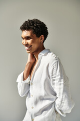 Obraz premium Handsome young man with a bright smile enjoying a sunny moment indoors