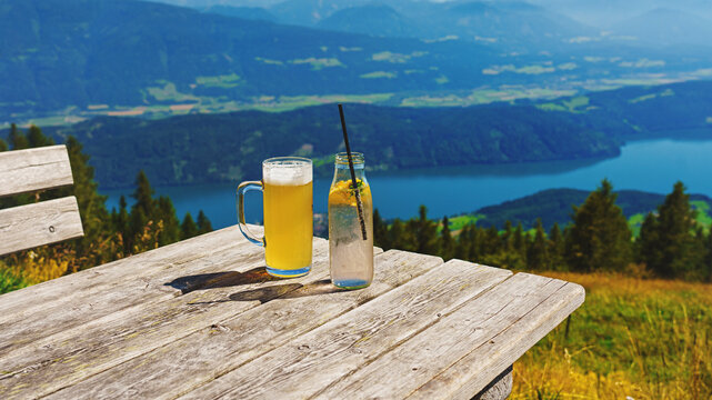 A wooden table with refreshing drinks. Beer and soft drinks in the Alps