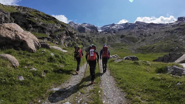POV hiking with three male mountaineers and mountain glacier panorama in summer in Pennine Alps, Italy