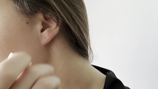 Close-up video of a woman taking off an earring. Beauty and personal care scene representing jewelry, fashion, femininity and everyday routine.
