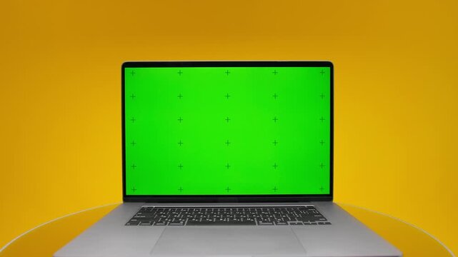 Laptop green screen on yellow background