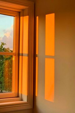Golden sunset light through window creating shadow patterns indoors