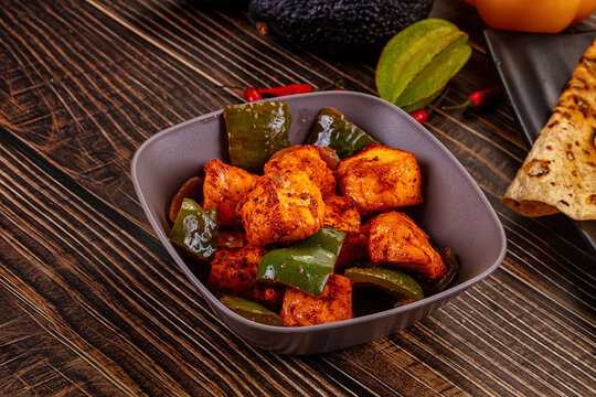 Indian Paneer Tikka Masala inl with Roti bread on a dark wooden table