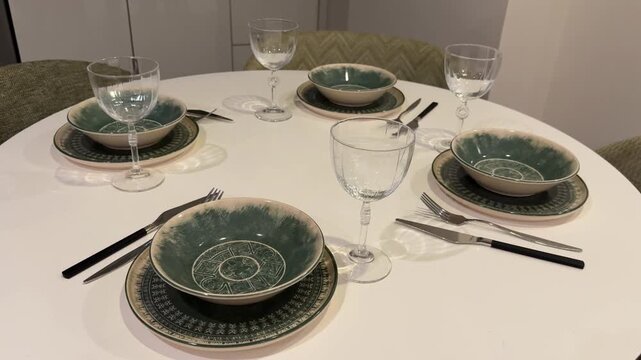 Dining table set with plates and glasses arranged for a meal in an elegant, cozy setting