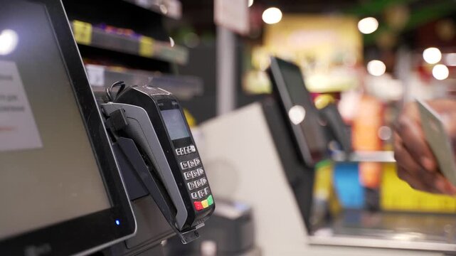 Close up african american male hand with credit card at counter buy electronic payment in supermarket. Pay for purchases in store. Contactless NFC pos terminal. Closeup card reader at cashless wallet