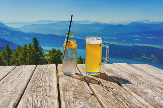  A wooden table with refreshing drinks. Beer and soft drinks in the Alps