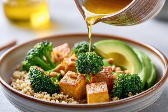 Gluten-free vegetarian quinoa bowl with tempeh, broccoli, and avocado served in a rustic ceramic bowl with dressing