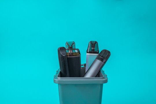 Various Electronic Cigarettes Thrown In Trash Can Quitting Vaping Concept