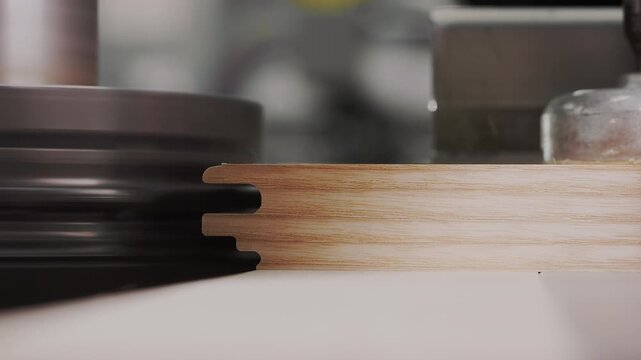 Close up of woodworking machine milling groove in wooden furniture panel at factory. Precision wood processing and furniture manufacturing concept.