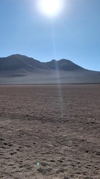 Scenic view of the Siloli Desert plain with volcanic mountains under a clear blue sky, majestic arid wilderness landscape of the Eduardo Avaroa National Reserve, Altiplano region, Bolivia