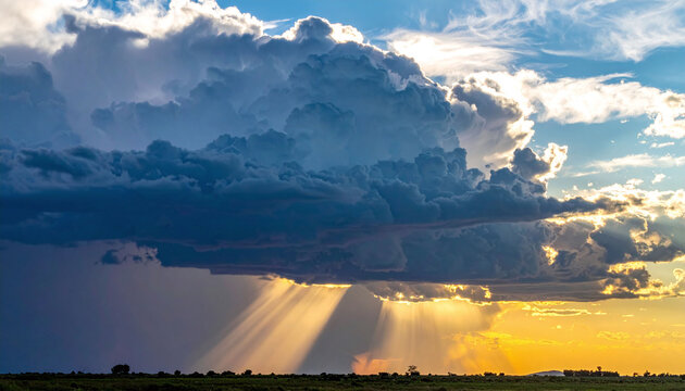 Breathtaking dramatic storm clouds at sunset with divine sunbeams breaking through. A powerful metaphor of hope and light over a flat horizon, perfect for creative and nature backgrounds.