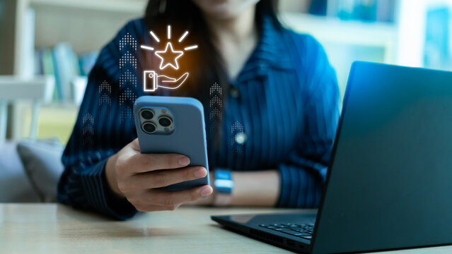 Loyalty rewards and redeem points concept with smartphone app. Close up of woman using mobile phone with glowing star icon for customer privilege, membership bonus, and marketing promotion program