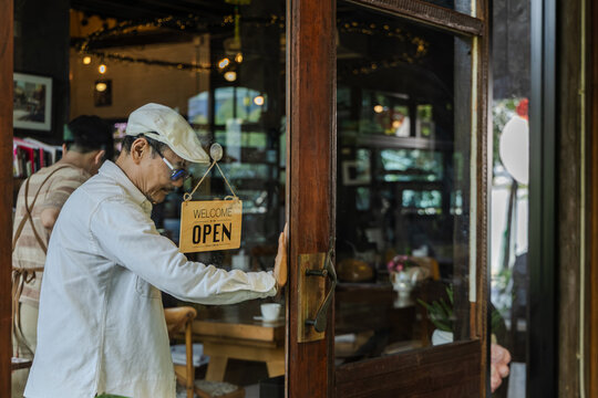 family small business coaching, senior cafe owner giving instruction to young son barista standing at storefront, learning by doing with new generation, leadership daily operation guidance concept.