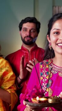 Indian family of four sings aarti and seeking blessings of Ganapati Bappa in beautifully adorned home surrounded by samai and embracing the spirit of devotion and togetherness