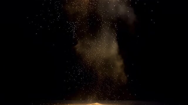A mesmerizing slow motion capture of sand and dust exploding upwards and gradually settling against a stark black background.