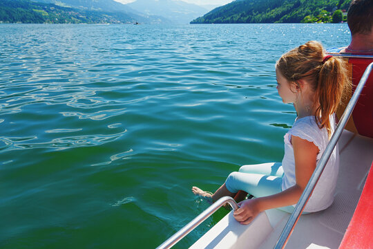 A girl rides a catamaran on vacation. Mountain lake.