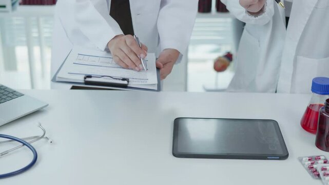 Medical Professionals Reviewing Tablet Treatment Chart in Clinical Office Healthcare Environment Focus on Technology and Collaboration