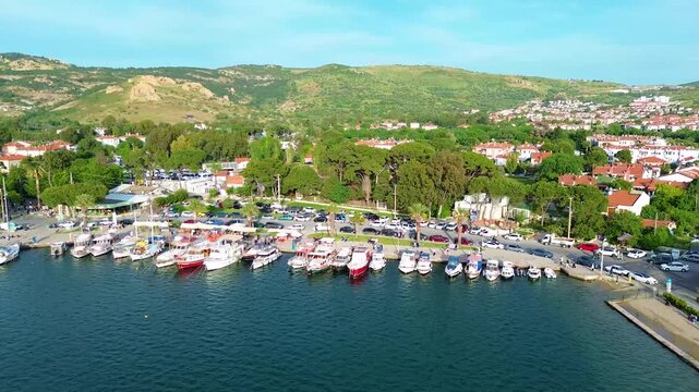 Scenic coastal town with boats docked and hills in the background. Turkey, Izmir, Eski Foca