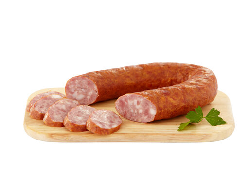Sliced smoked sausage on wooden cutting board with parsley, cooked meat links isolated on transparent background PNG