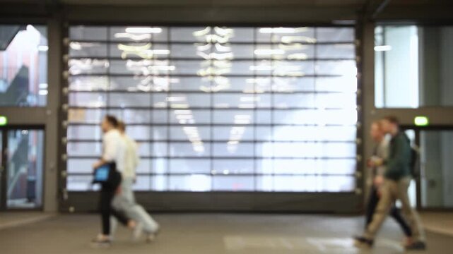 Blurred motion of people walking at a trade fair, showcasing the bustling atmosphere and movement within the event.