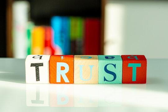 Wooden alphabet blocks spelling out the word TRUST.