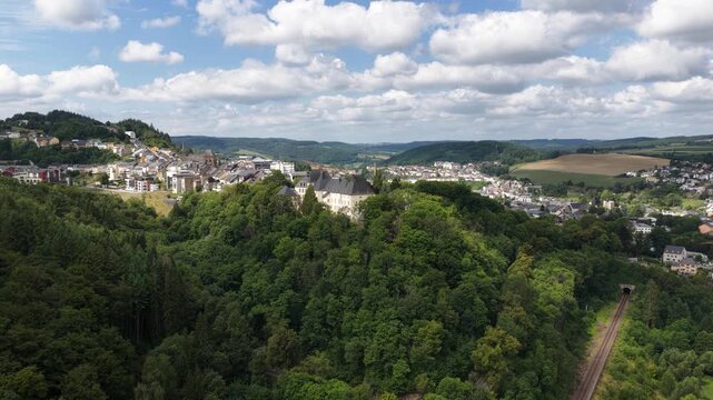 Aerial view of clervaux castle in luxembourg surrounded by forest