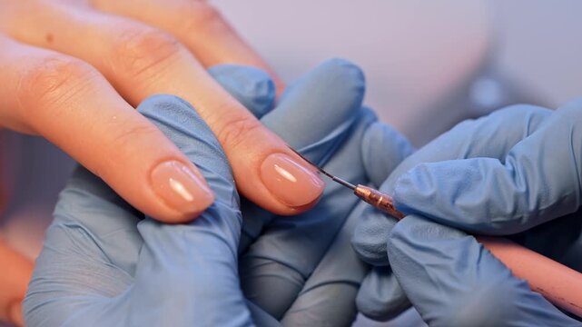 Macro salon shot of a nail technician tracing the sidewall of a glossy nude manicure with a fine liner tool, emphasizing precision finishing and premium minimalist beauty care.