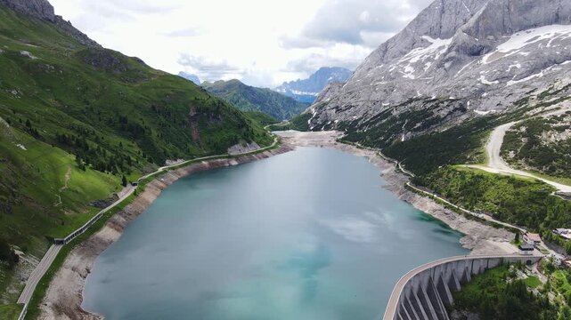 Cinematic view, Lago Fedaia beneath Marmolada in Dolomites Italy turquoise water