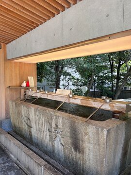 Traditional Japanese shrine purification fountain with wooden architecture