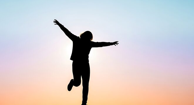 Silhouette of a Person Dancing Joyfully Against a Vibrant Sunset Sky.