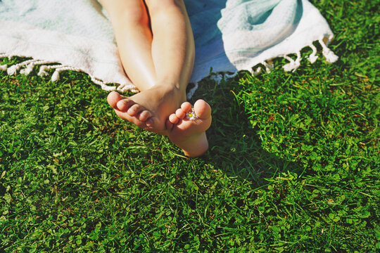 barefoot on soft green grass, closeup. Sunbathing on the green beach.