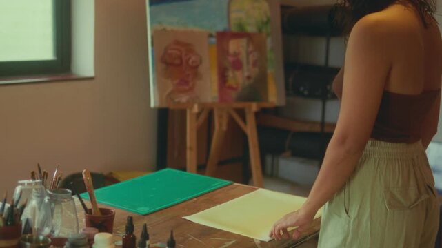 Female Artist Preparing Workspace with Materials in Art Studio