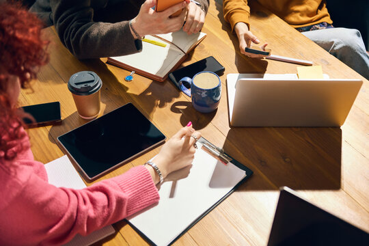 Close up of work table with laptops notebooks coffee and phones. Concept of planning, business workshop, student projects, office workflow, online study, and creative research.
