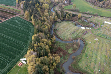 Fototapeta premium Aerial drone view of winding river flowing through farmland in Oregon USA scenic Pacific Northwest landscape with agricultural fields and natural environment