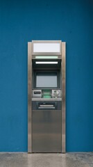 Fototapeta premium Modern ATM Machine Standing Against Vibrant Blue Wall With Sleek Metallic Finish