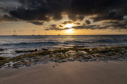 A spectacular sunset over the golden sand and Atlantic ocean seen from the popular Bikini beach at the island of Sal in Cape Verde. It is a nice stretch of beach with a calm cove area that's great for