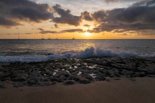 A spectacular sunset over the golden sand and Atlantic ocean seen from the popular Bikini beach at the island of Sal in Cape Verde. It is a nice stretch of beach with a calm cove area that's great for