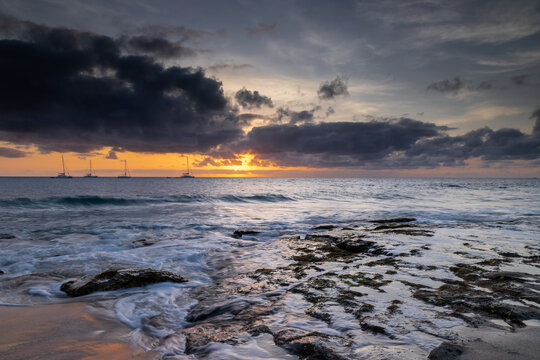 A spectacular sunset over the golden sand and Atlantic ocean seen from the popular Bikini beach at the island of Sal in Cape Verde. It is a nice stretch of beach with a calm cove area that's great for