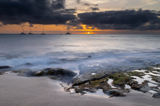 A spectacular sunset over the golden sand and Atlantic ocean seen from the popular Bikini beach at the island of Sal in Cape Verde. It is a nice stretch of beach with a calm cove area that's great for