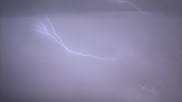 Isolated lightning bolt in the night sky, captured in slow motion.