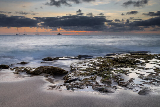A spectacular sunset over the golden sand and Atlantic ocean seen from the popular Bikini beach at the island of Sal in Cape Verde. It is a nice stretch of beach with a calm cove area that's great for